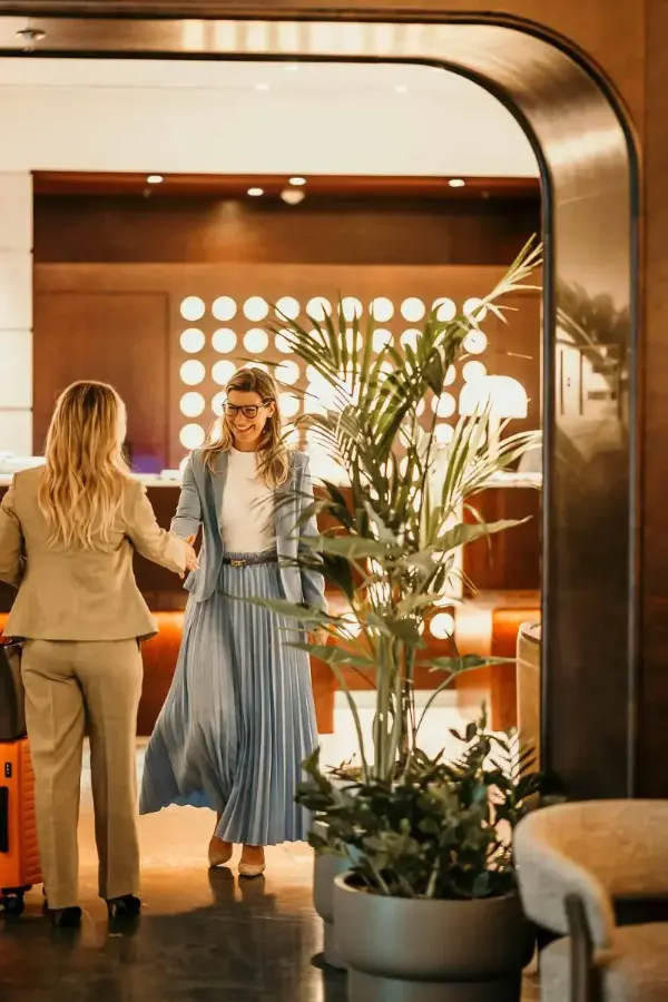 Beraterin begrüßt einen Gast in einer Hotellobby