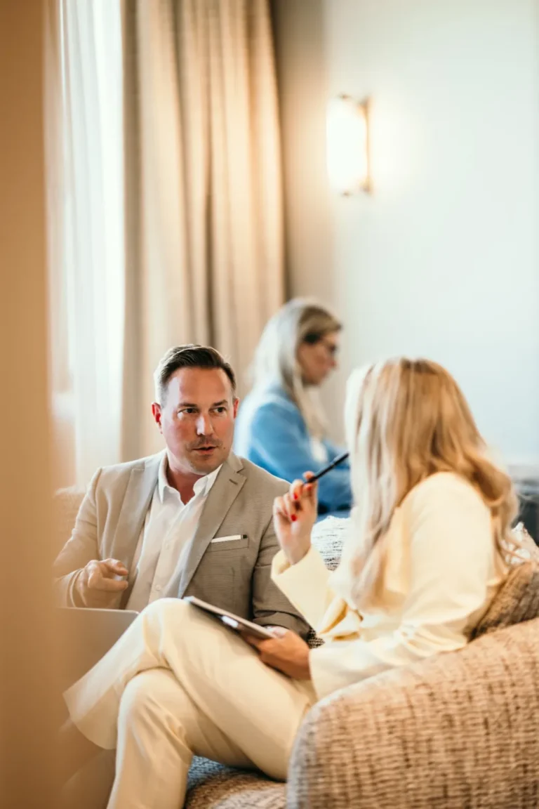 Hotelspezialist und Hotelspezialistin im Gespräch in einer ruhigen Hotellounge